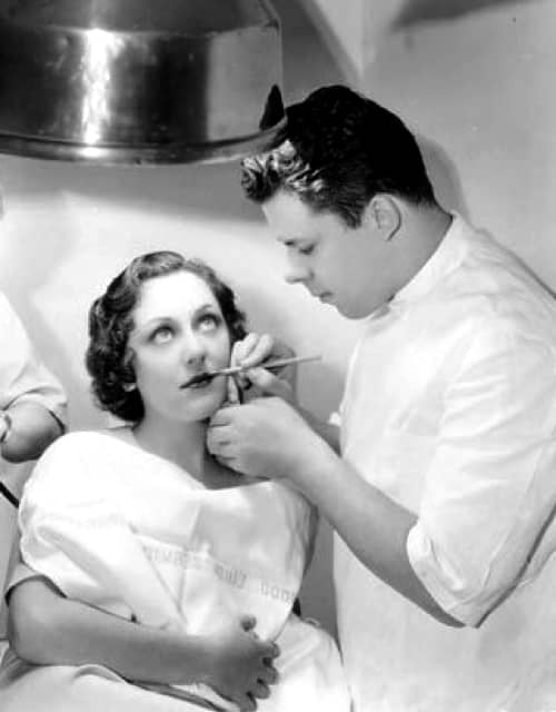 Perc Westmore using a lipstick brush on Ann Dvorak