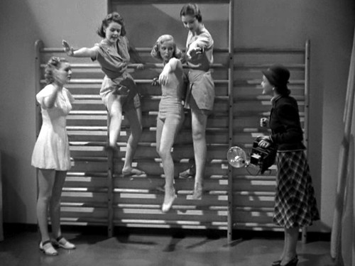 Women exercising on gymnasium bars